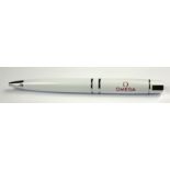 OMEGA, GIVEAWAY, A WHITE BALLPOINT PEN Stainless steel mounts and red enamel monogram, in a fitted