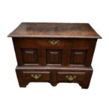 AN 18TH CENTURY WELSH OAK COFFOR BACH with rise and fall top above fielded panels and two drawers,