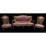 A FRENCH EMPIRE STYLE GILTWOOD SETTEE Together with a pair of matching chairs, decorated with carved