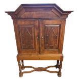 A 17TH CENTURY STYLE DUTCH CABINET ON STAND With architectural cornice above Gothic panelled doors