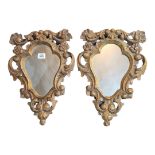A PAIR OF 19TH CENTURY CONTINENTAL CARTOUCHE CARVED PINE FRAMED MIRRORS Florets and scrolls, with