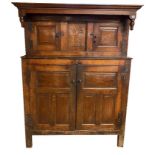 AN 18TH CENTURY OAK COURT CUPBOARD With four fielded panelled doors centred with a central sliding