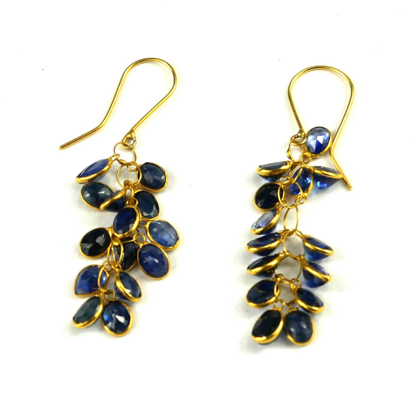A PAIR OF YELLOW METAL AND SAPPHIRE DROP EARRINGS Having an arrangement of oval cut stones. (tests