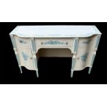 A MID 20TH CENTURY CREAM PAINTED AND BLUE FLORAL DECORATED KNEEHOLE DRESSING TABLE With three