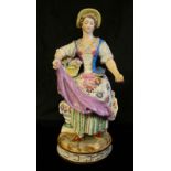 MEISSEN, AN EARLY 19TH CENTURY PORCELAIN FIGURE, A YOUGN WOMAN HOLDING A BASKET OF FLOWERS In a long