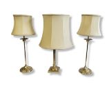 A PAIR OF SOLID BRASS BEDSIDE CABINET LAMP BASES Slim elegant columns, on circular bases, complete