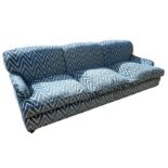 IN THE STYLE OF HOWARD AND SONS, A LARGE THREE SEATER SETTEE In a blue cut velvet upholstery on a