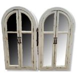 A PAIR OF GOTHIC STYLE ARCH SHUTTER MIRRORS With distressed off white decoration applied to panels