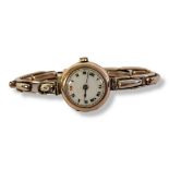 ROLEX, AN EARLY 20TH CENTURY 9CT GOLD LADIES’ WRISTWATCH Having a circular white dial with red