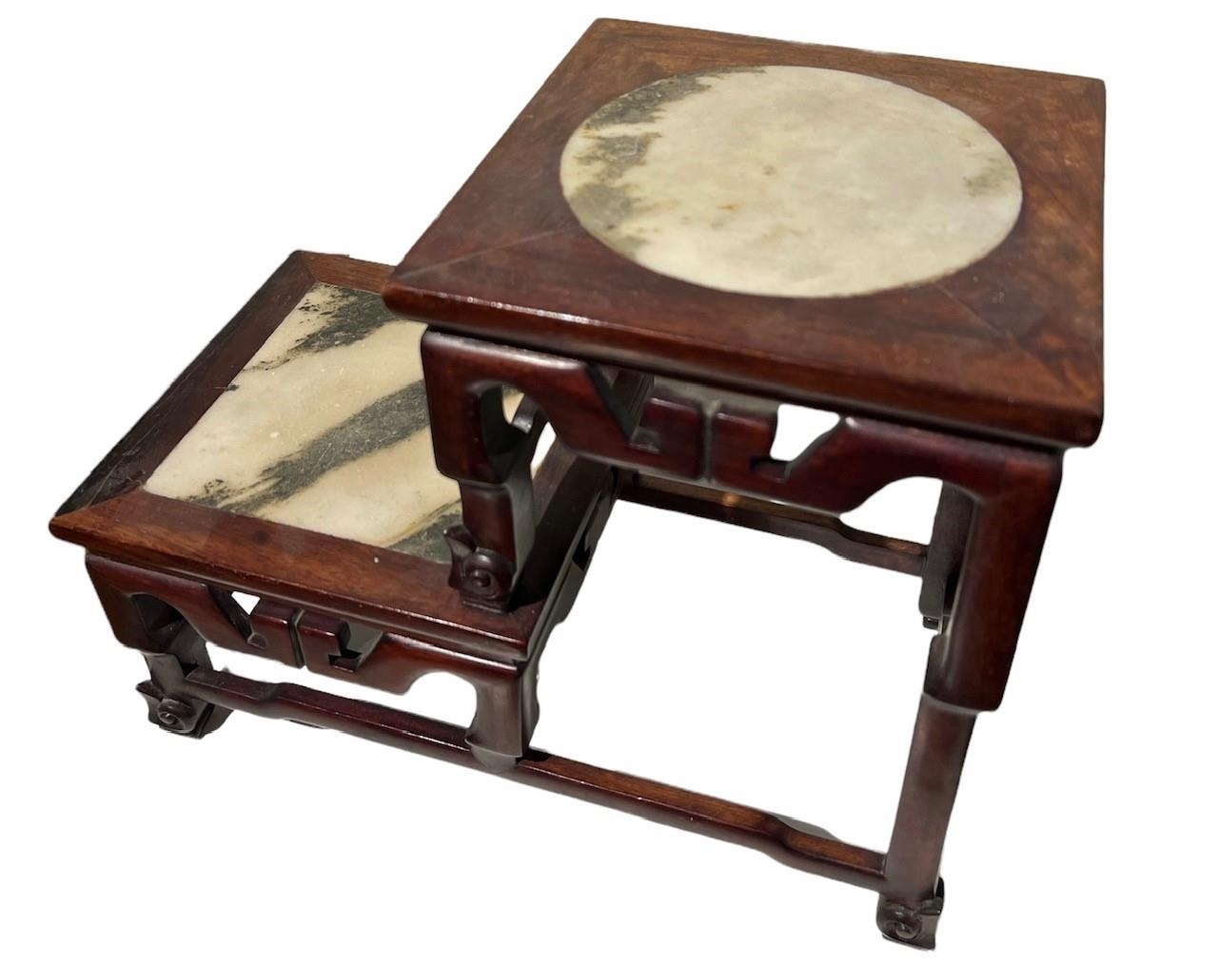 A CHINESE MARBLE INSET HARDWOOD TWO TIER TABLE STAND The square top set with a circular and square