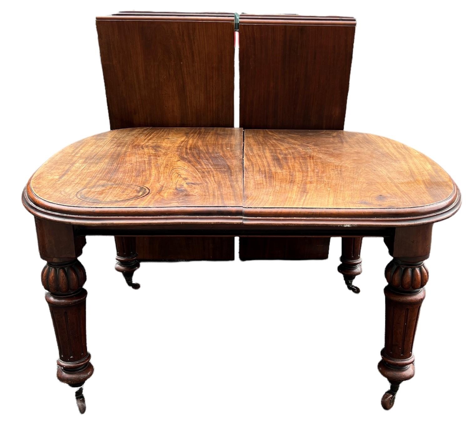 A 19TH CENTURY SOLID MAHOGANY EXTENDING DINING TABLE With two extra leaves, raised on bulbous and