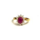 A 9CT GOLD, OVAL CUT RUBY AND DIAMOND CLUSTER RING. (ruby 1.72ct, diamonds 0.06ct)
