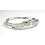 AN 18CT WHITE GOLD BAGUETTE AND BRILLIANT CUT DIAMOND BANGLE Boxed, with WGI certificate. (total 2.