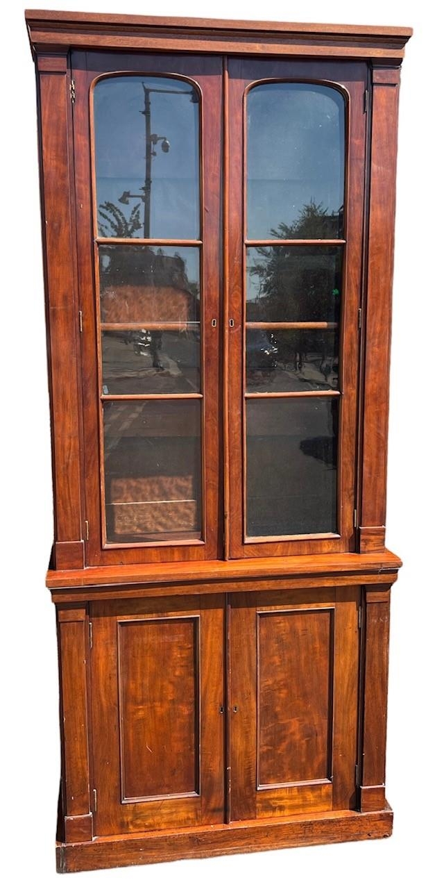 AN EARLY 19TH CENTURY MAHOGANY GLAZED BOOKCASE With shelf interior above a pair of panelled doors