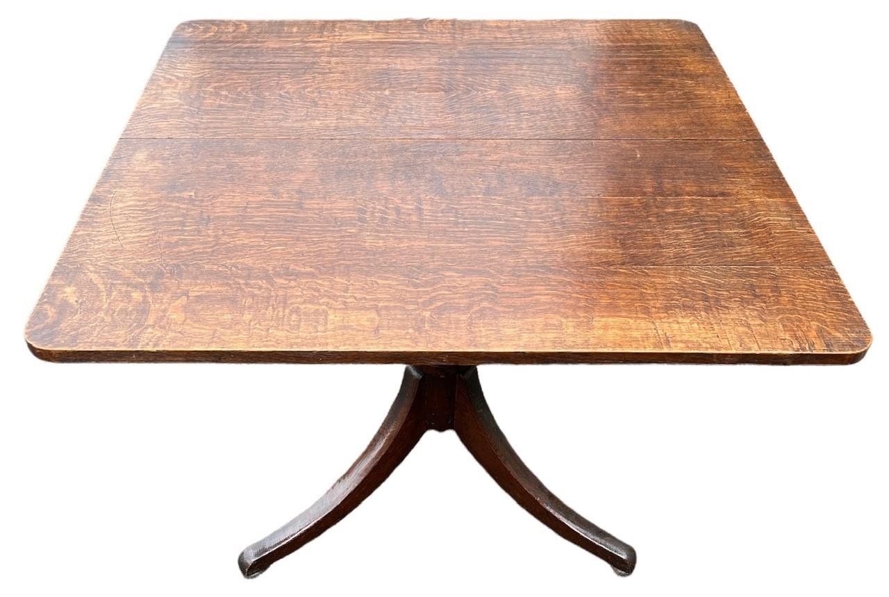 A GEORGE III OAK TILT TOP BREAKFAST TABLE The square top raised on turned a column and support, on