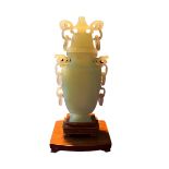 A CHINESE BOWENITE STYLISED URN HAVING SIX HANDLES WITH LOOSE RINGS Raised upon a two tier wooden