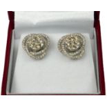 A PAIR OF STYLISH SWIRLING 18CT WHITE GOLD AND DIAMOND CLUSTER STUD EARRINGS Boxed. (diamonds 1.