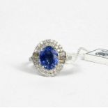 AN 18CT WHITE GOLD CLUSTER RING set with oval mixed cut sapphire and round brilliant cut and