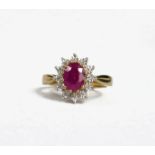 A 9CT YELLOW GOLD OVAL RUBY AND DIAMOND CLUSTER RING. (Ruby 1.61ct Diamonds 0.06ct)