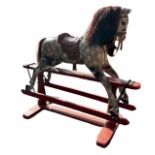 A LATE 19TH/EARLY 20TH CENTURY CARVED WOOD DAPPLE GREY PAINTED ROCKING HORSE With leather saddle and