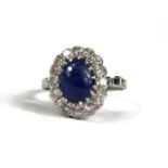 A WHITE METAL RING WITH CABOCHON SAPPHIRE AND ROUND EIGHT CUT DIAMONDS. (Sapphire approx. 2.00ct.