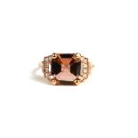 AN 18CT ROSE GOLD RINGset with octagonal step cut tourmaline and round brilliant cut and baguette