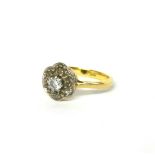 AN EARLY 20TH CENTURY 18CT GOLD AND DIAMOND CLUSTER RING The central round cut diamond edged with