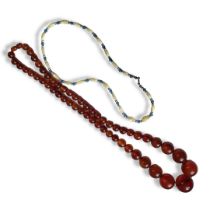 AN EARLY 20TH CENTURY AMBER NECKLACE A row of graduated spherical beads, together with a sapphire
