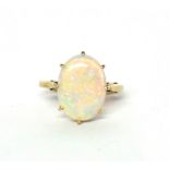 A VINTAGE 9CT GOLD AND OPAL RING The oval cabochon cut stone on plain gold. (opal approx 1.5cm x