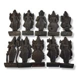 A SET OF TEN EARLY 20TH CENTURY NORTH INDIAN CARVED WOOD DIETY PANELS All exotic dark patinated wood