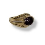 A VINTAGE YELLOW METAL AND AMETHYST GENTS SIGNET RING Having a single oval cut stone and engraved