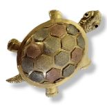 A VINTAGE TRICOLOUR METAL TURTLE PENDANT Having ruby set eyes and tricolour finish to shell. (approx