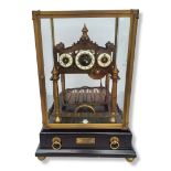 A LARGE BRASS CONGREVE ROLLING BALL CLOCK With three enamel dials, a fusèe movement within glazed