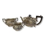 AN EDWARDIAN SILVER THREE PIECE TEA SET Comprising a teapot, sugar basin and cream jug, having