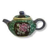 A 20TH CENTURY CHINESE POTTERY TEAPOT Having floral decoration within a green glaze border,