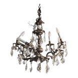 AN EARLY 20TH CENTURY BRASS AND CUT GLASS CHANDELIER Having six scrolled branch arms and faceted cut