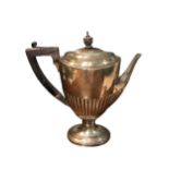 A LATE VICTORIAN SILVER COFFEE POT Having a wooden finial and thumb gripped handle, fluted body