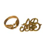 A YELLOW METAL RING SHANK AND STYLISED MONOGRAM (BOTH TESTED FOR 18CT YELLOW GOLD). (9.8g)