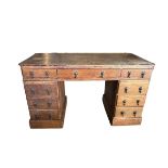 A 19TH CENTURY VICTORIAN OAK PEDESTAL DESK Having an arrangement of nine drawers, raised on a plinth