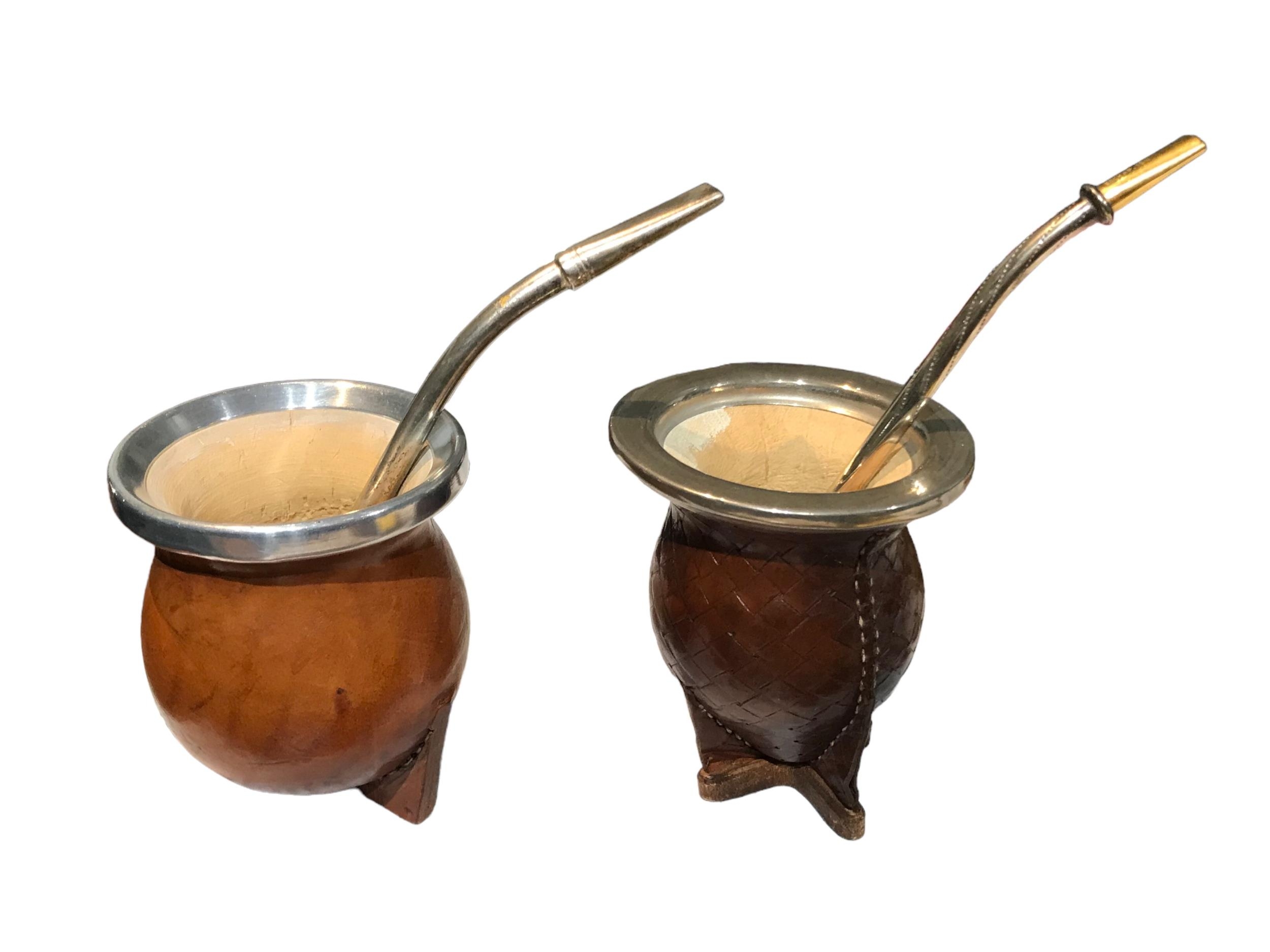 TWO 20TH CENTURY ARGENTINIAN YERBA MATES ON HAVING 18CT GOLD ENCHAP STRAW TIP. (largest h 10.3cm x