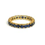 A YELLOW METAL (TESTS AS 18CT GOLD) AND SAPPHIRE ETERNITY RING. (UK ring size K½ , gross weight 1.