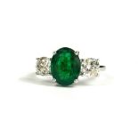 AN 18CT WHITE GOLD OVAL EMERALD AND DIAMOND THREE STONE RING. (Emerald 3.75ct. Diamonds 1.41ct)