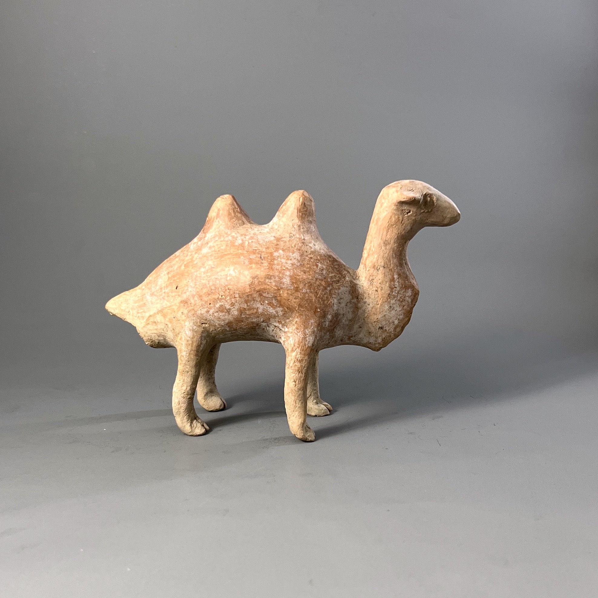 A Qijia style Pottery Camel L:17.7cm the smooth reddish buff pottery formed as a Bactrian camel