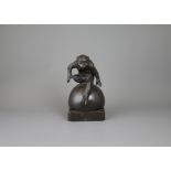 A Japanese Bronze Gibbon, Taisho period H:21.5cm with good dark patina, seated on a large ball as if