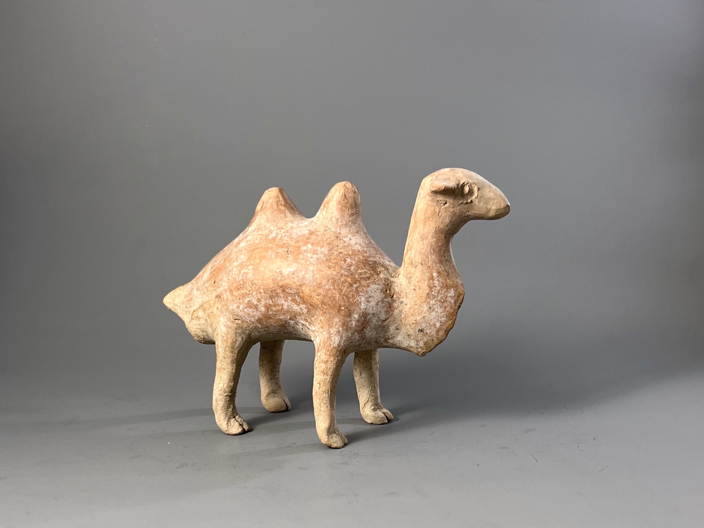 A Qijia style Pottery Camel L:17.7cm the smooth reddish buff pottery formed as a Bactrian camel - Image 2 of 7