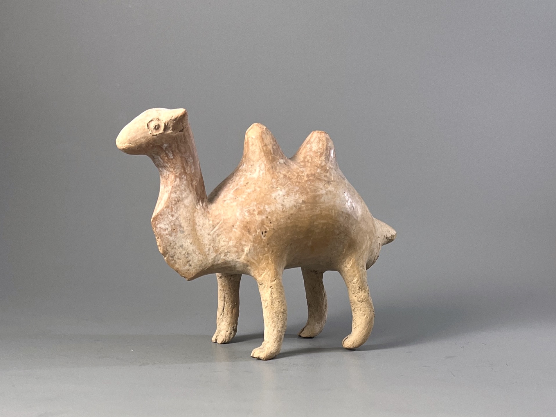 A Qijia style Pottery Camel L:17.7cm the smooth reddish buff pottery formed as a Bactrian camel - Image 5 of 7