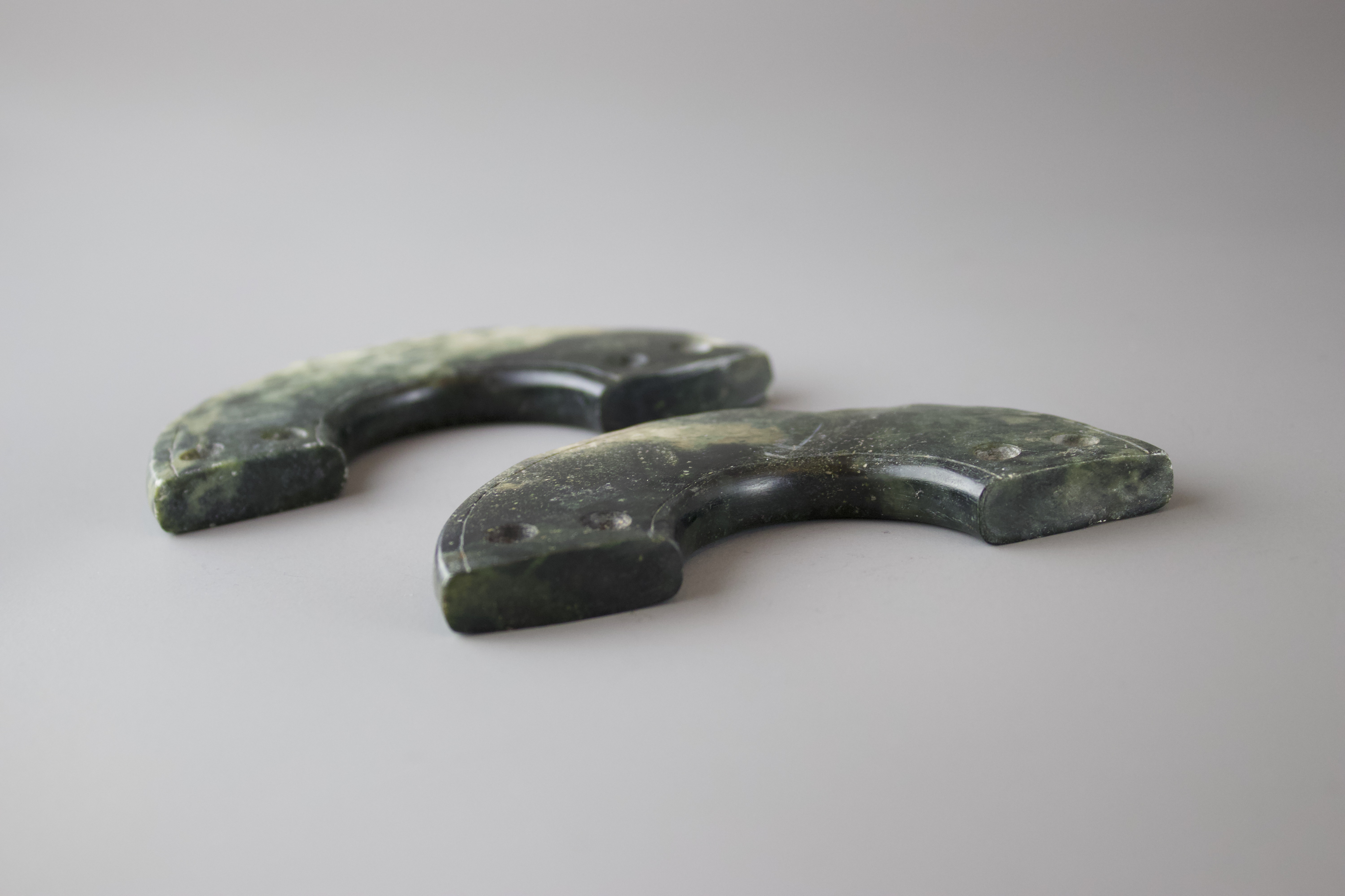 A Pair of Jade Huang, Neolithic or later each L: 10cm The two slim half discs carved from a dark - Image 2 of 2