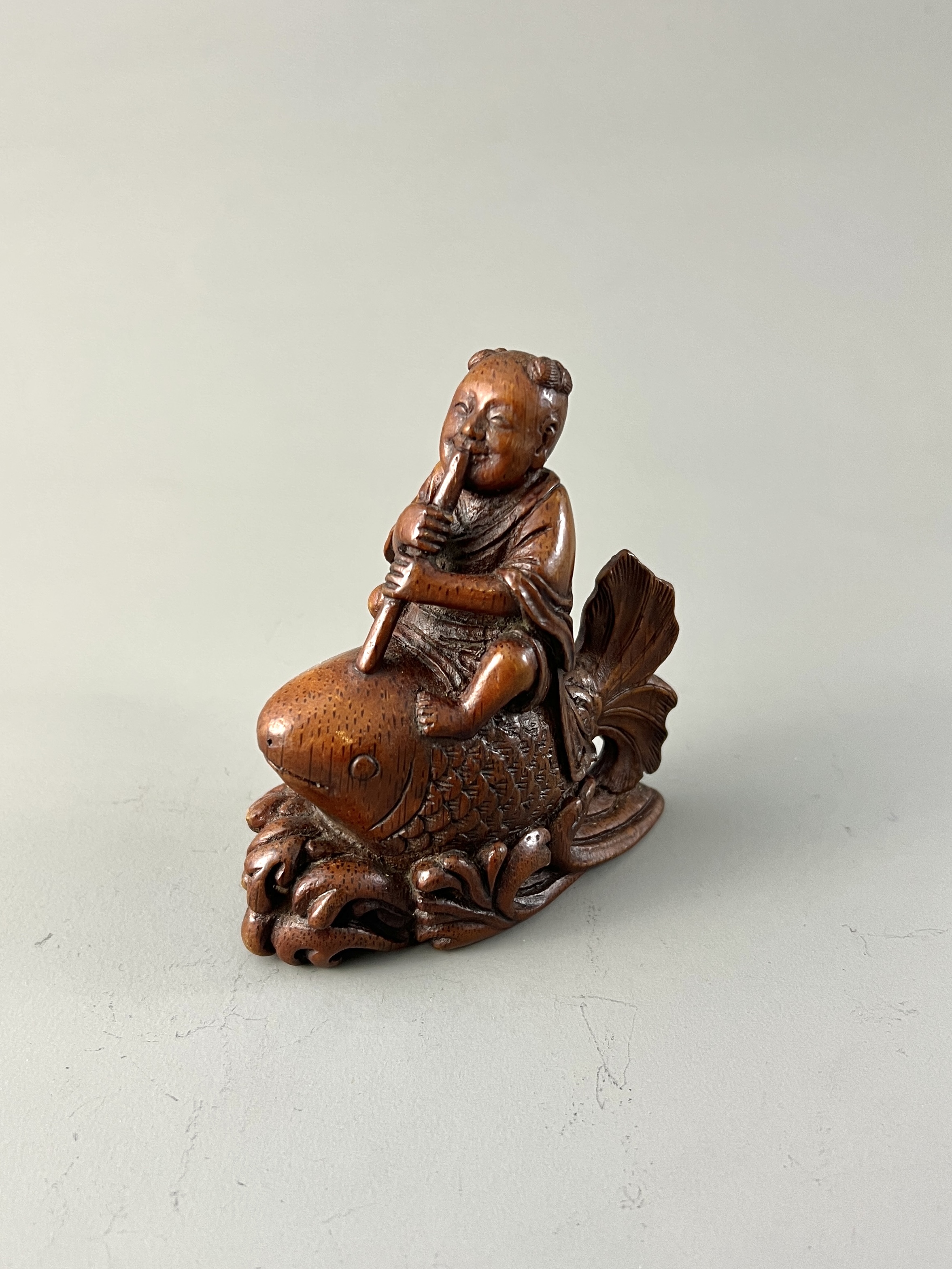 A Bamboo Boy and Carp H:9.7cm the boy playing the flute as he rides a giant carp among waves