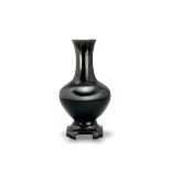 A Black Glazed Bottle Vase H:18.4cm of shouldered form with angled foot and slightly waisted neck In