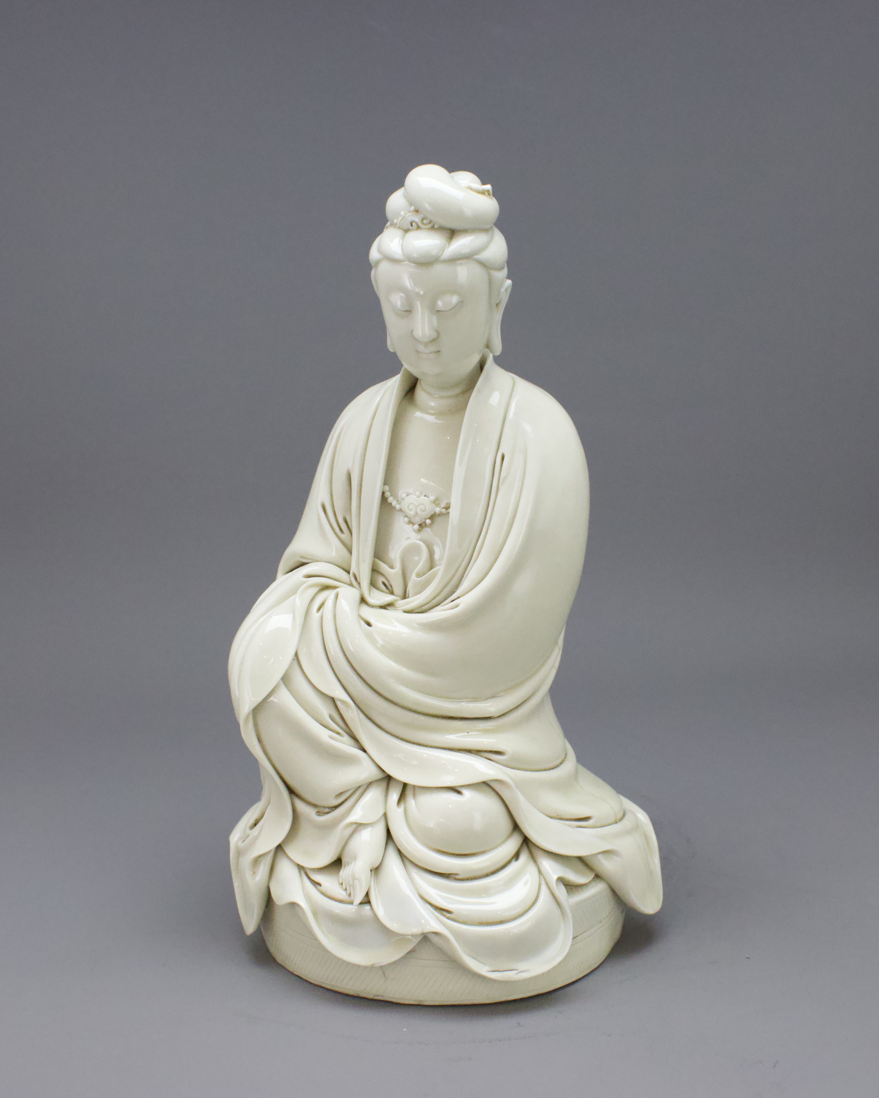 A Dehua Seated Figure of Guanyin, three character impressed sealmark He Chaozong H:28.8cm finely